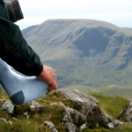 Hiker takes a break to rub his sore foot