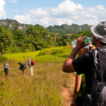 Man drinking water from a bottle while hiking